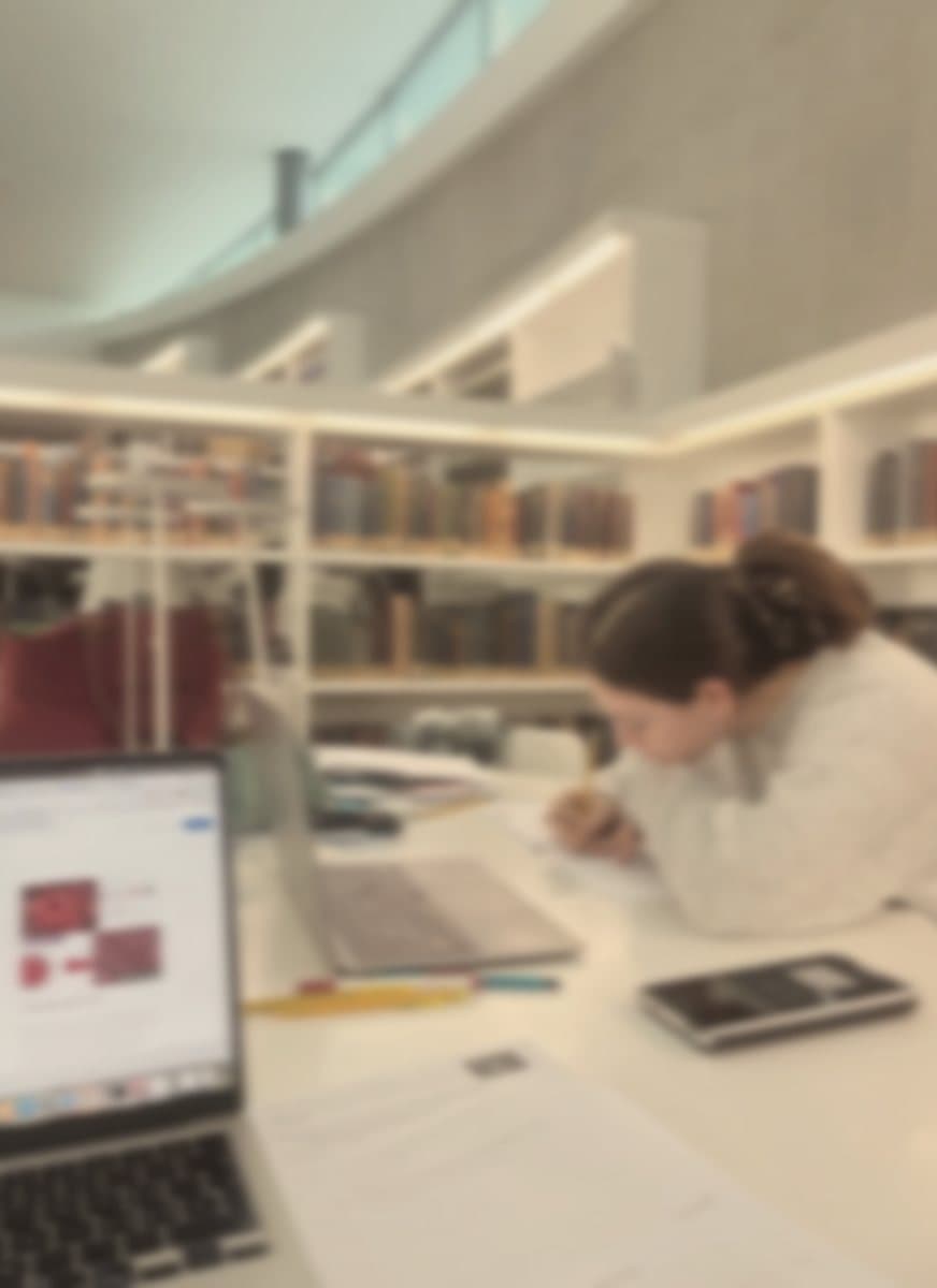 A student writing out a worksheet in a library